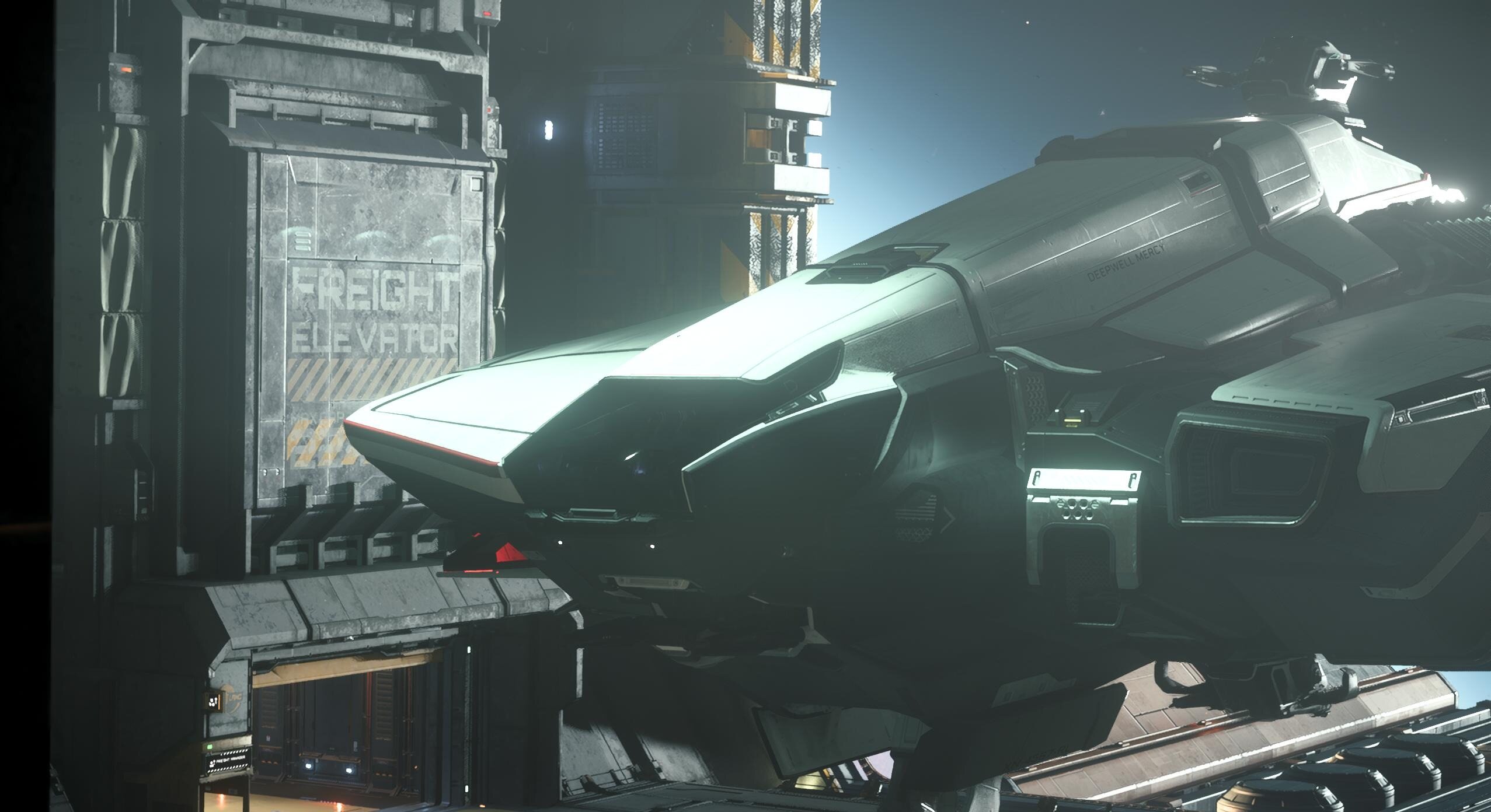 Deepwell Mercy parked near freight containers in a hangar bay.